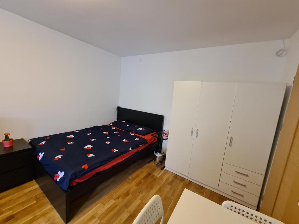 een slaapkamer met een bed met een blauw dekbed en een nachtrok bij MirrorRoom PL CityCenter in Warschau
