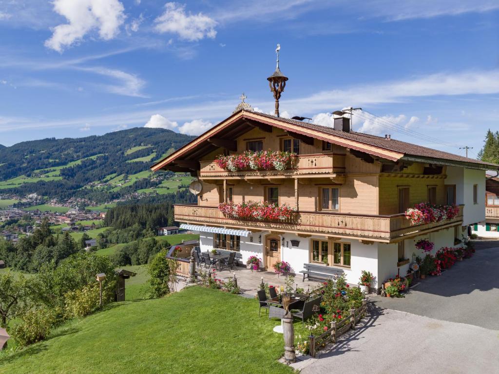 une maison au sommet d'une colline avec des fleurs dans l'établissement Grillinghof, à Kirchberg in Tirol