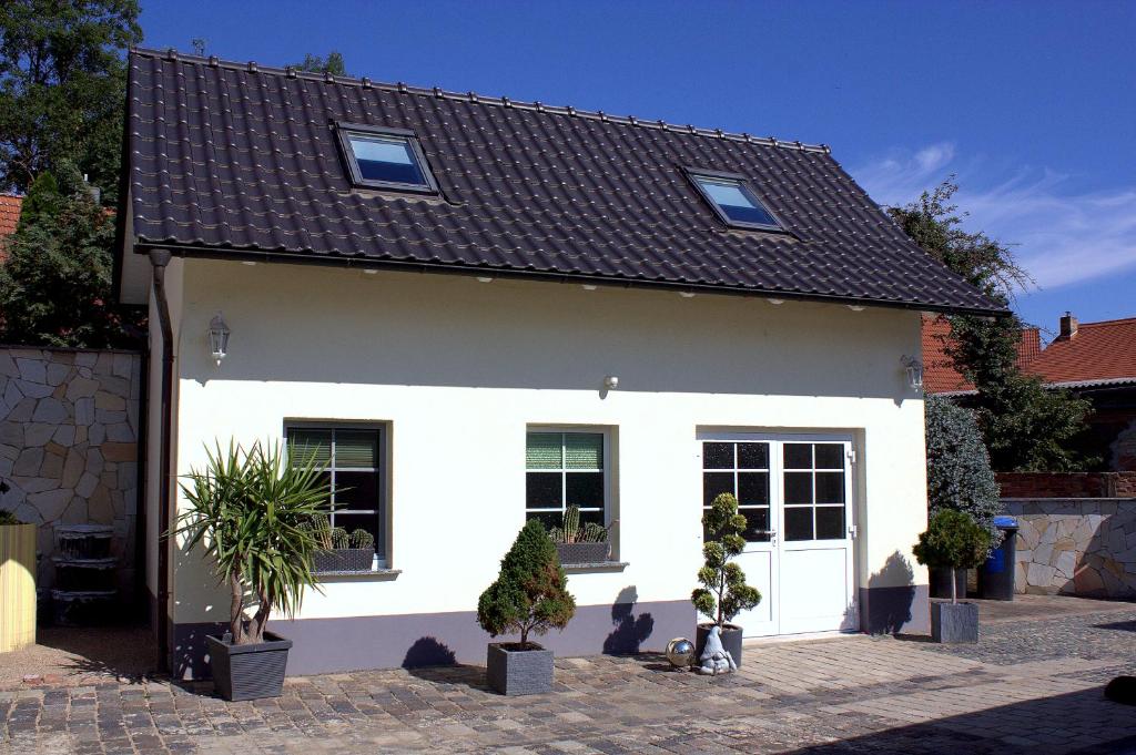 een wit huis met een zwart dak bij Ferienhaus Zum Gässchen in Weißenfels