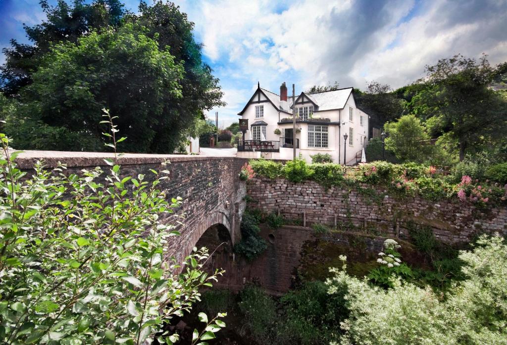 una casa seduta in cima a un ponte di pietra di The Newbridge on Usk a Usk