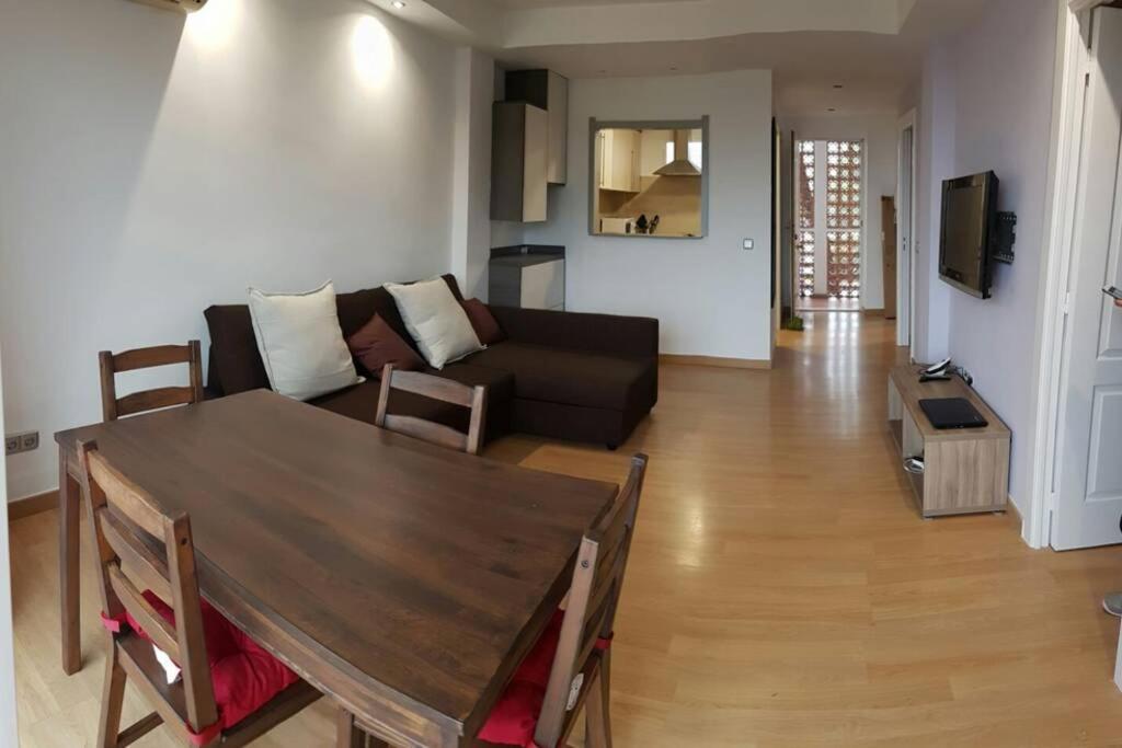 een woonkamer met een tafel en een bank bij Acogedor apartamento familiar in Marbella