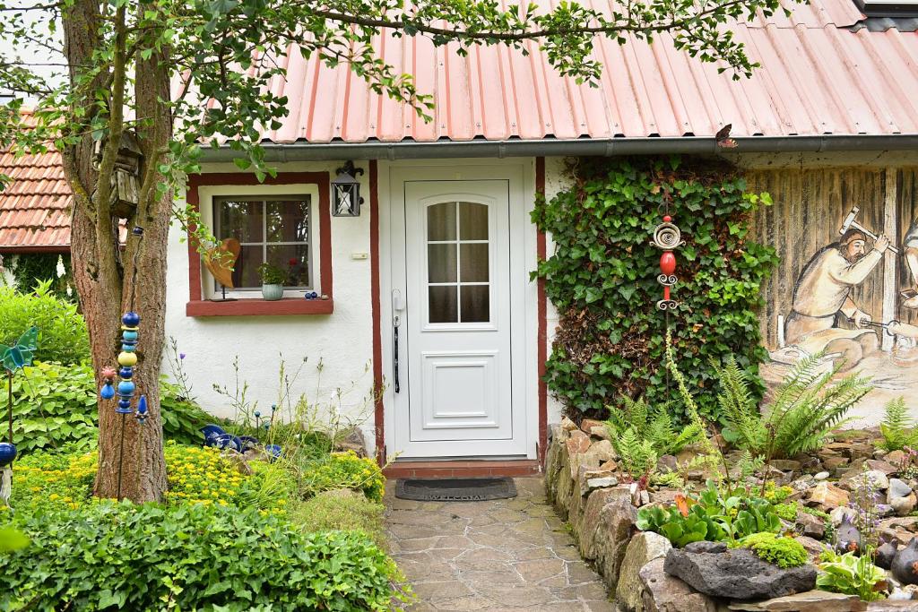 ein weißes Haus mit einem roten Dach und einer Tür in der Unterkunft Ferienwohnung Axcher Hof in Weitersborn