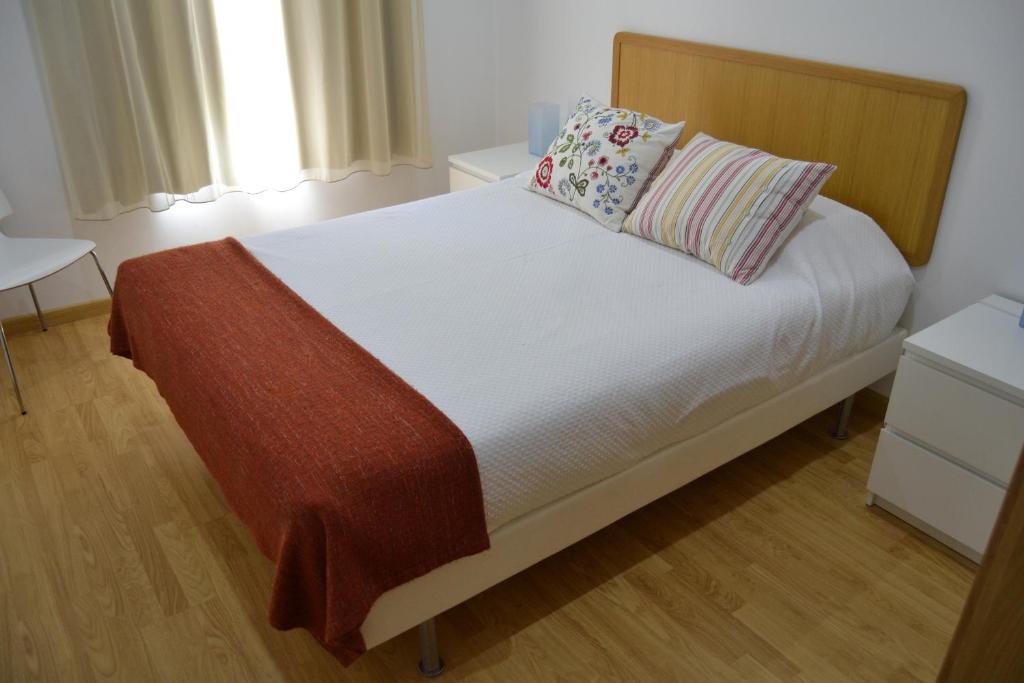 een slaapkamer met een bed met witte lakens en kussens bij Cerca da Vitoria 2 Sesimbra in Sesimbra