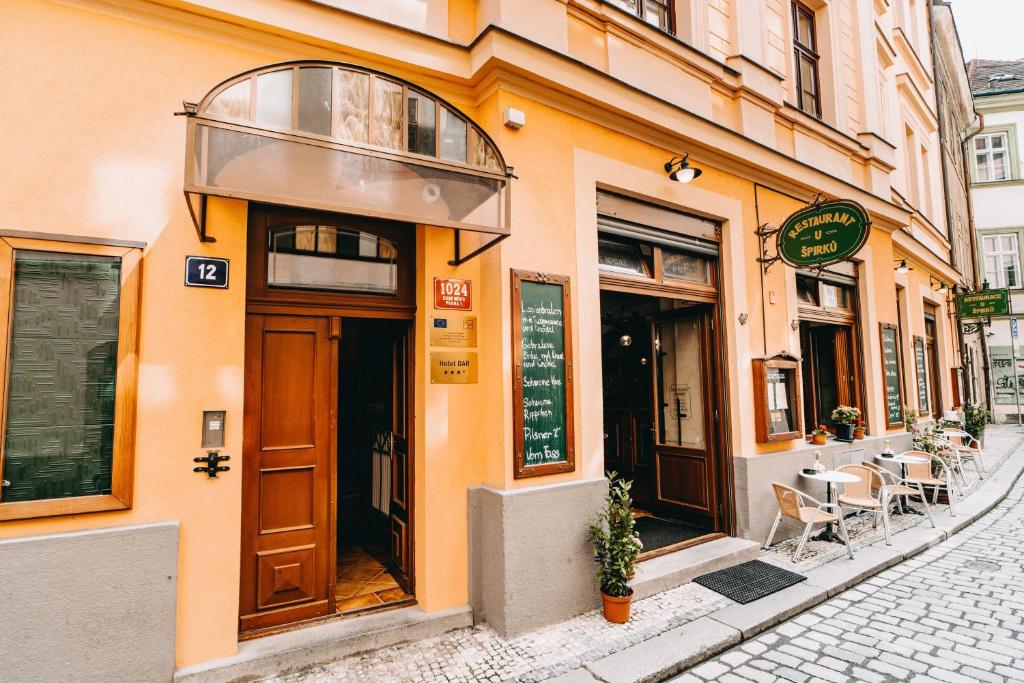 ein orangefarbenes Gebäude mit einer Tür auf einer Straße in der Unterkunft Hotel Dar in Prag