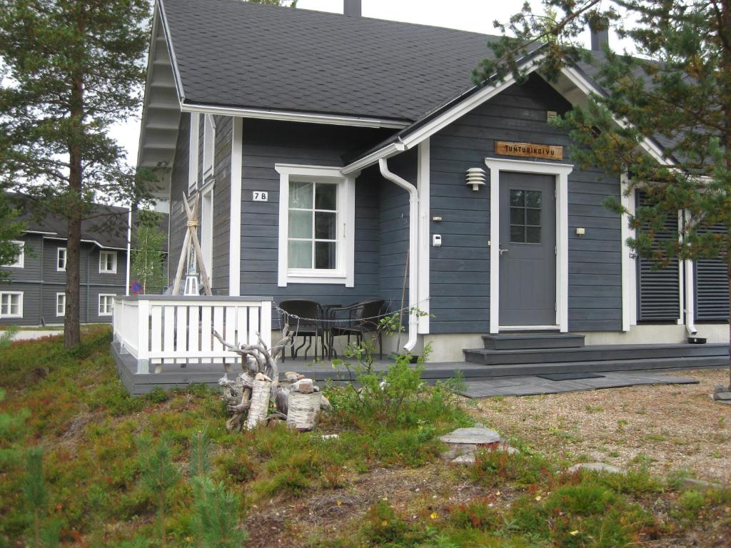 a blue house with a porch and a table at Tunturikoivu in Ylläsjärvi
