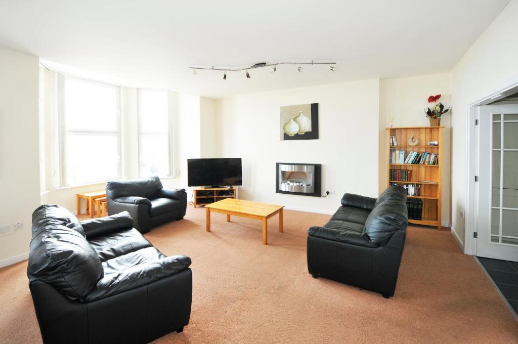 a living room with two leather couches and a table at Cunard Apartments in Douglas