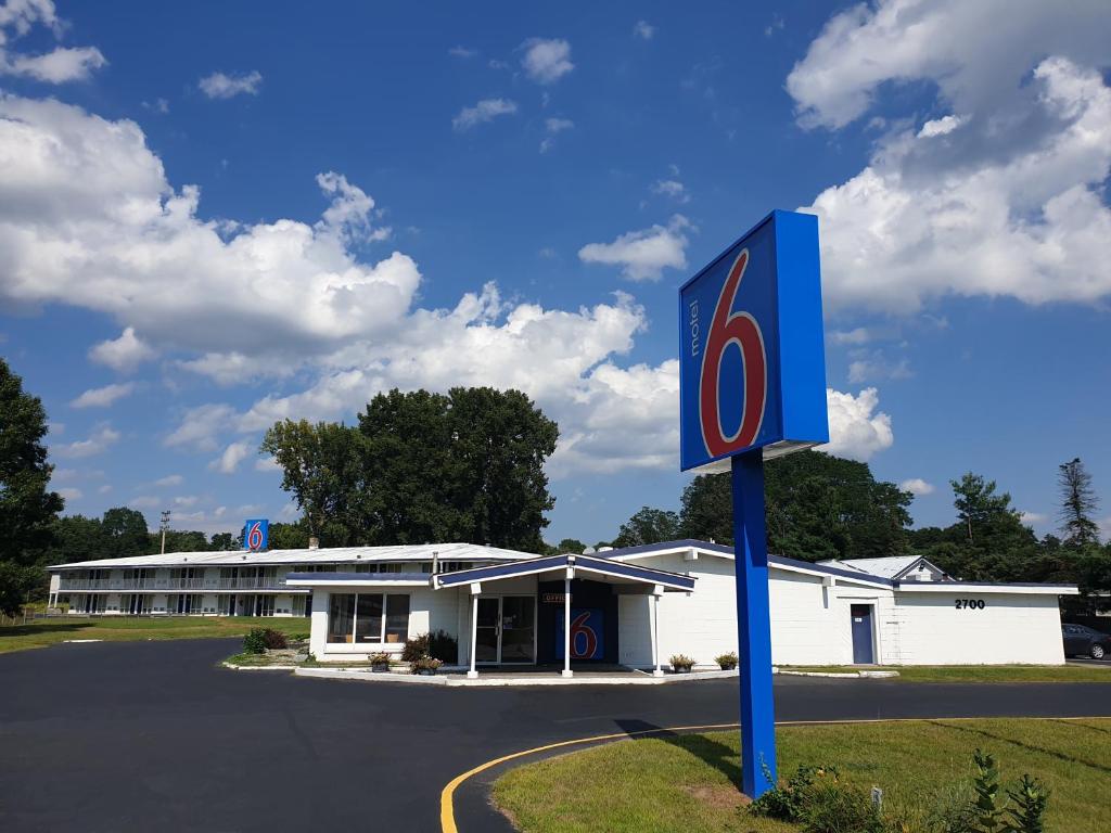 un bâtiment avec un panneau devant lui dans l'établissement Motel 6-Schenectady, NY, à Schenectady