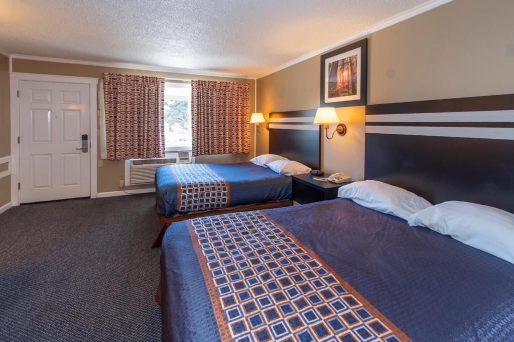 a hotel room with two beds and a window at Surf Motel and Gardens in Fort Bragg