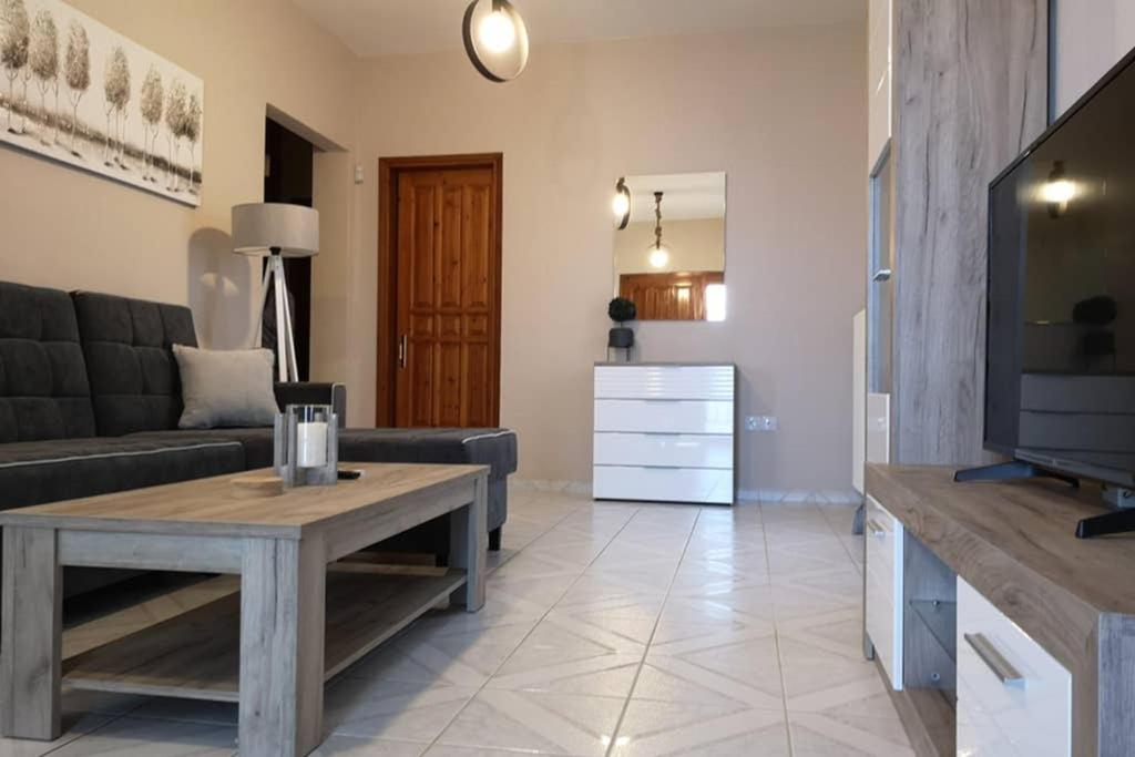 ein Wohnzimmer mit einem Sofa und einem Tisch in der Unterkunft Village View in Nea Epidavros