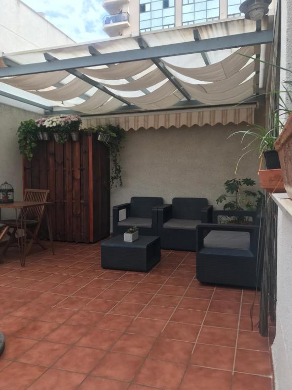 eine Terrasse mit einer Pergola, Stühlen und einem Tisch in der Unterkunft Habitación en Casa Qerétaro in Silla