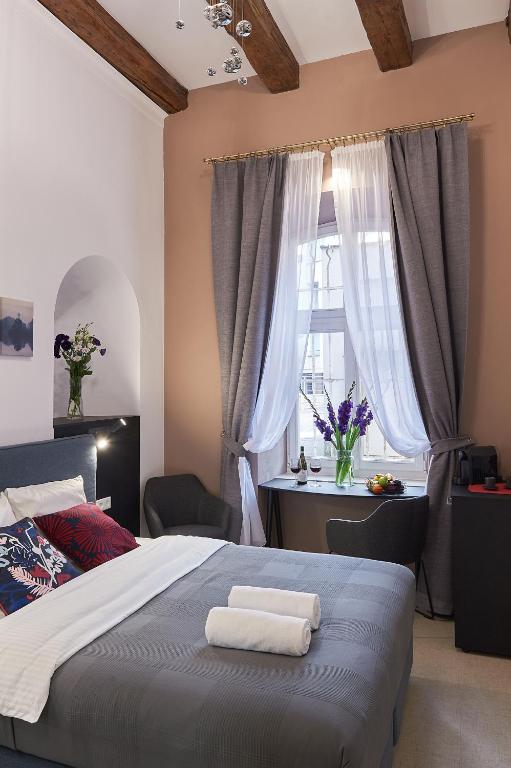 a bedroom with a bed with two towels on it at 7 HEAVEN Elegant Rooms KRAKÓW Old Town in Krakow