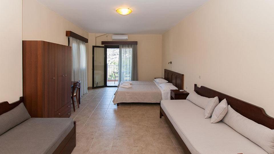 pokój hotelowy z 2 łóżkami i kanapą w obiekcie Anopoli Rooms w mieście Sinoikismós Kámbos