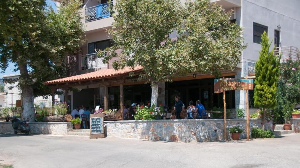 restauracja z ludźmi siedzącymi poza budynkiem w obiekcie Anopoli Rooms w mieście Sinoikismós Kámbos