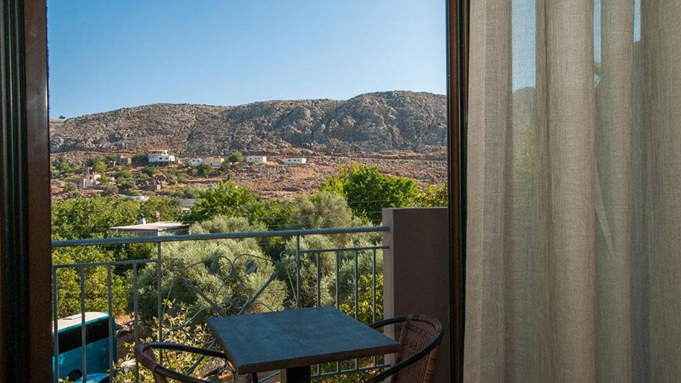 balkon ze stołem i widokiem na góry w obiekcie Anopoli Rooms w mieście Sinoikismós Kámbos