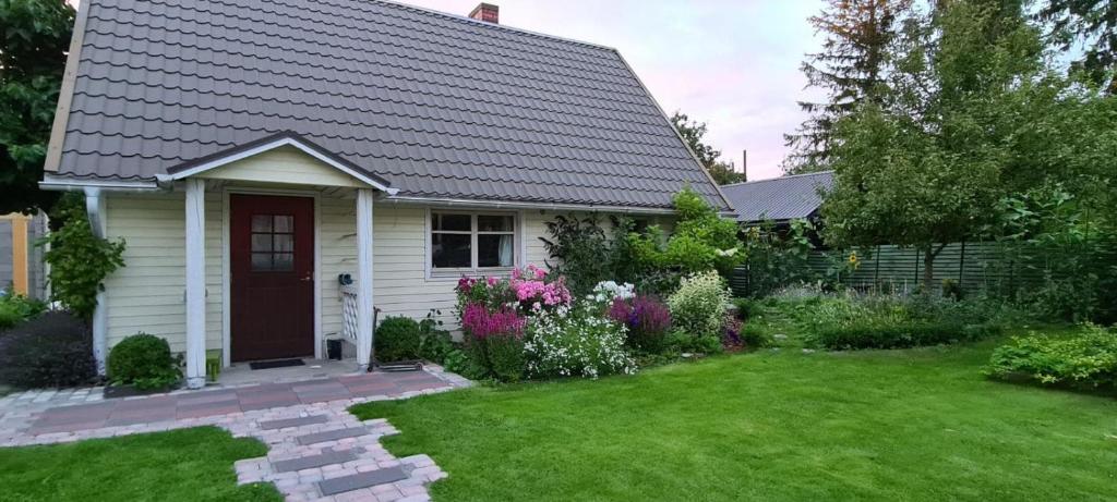 una pequeña casa blanca con un patio con flores en House in the City, en Tallin