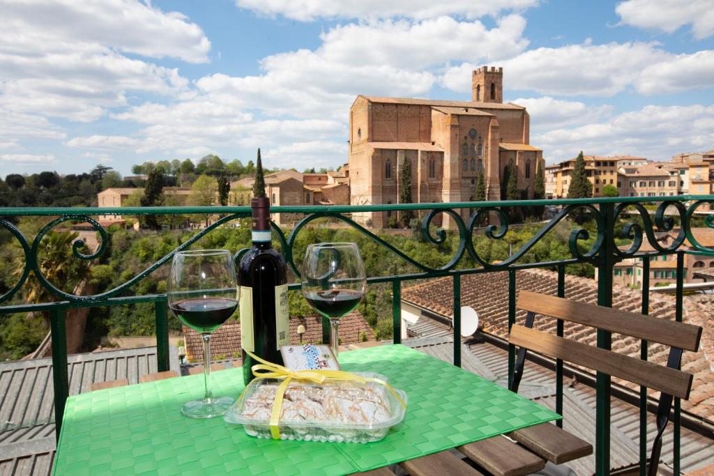 un tavolo con due bicchieri di vino sul balcone di Casa Siena Vallepiatta a Siena