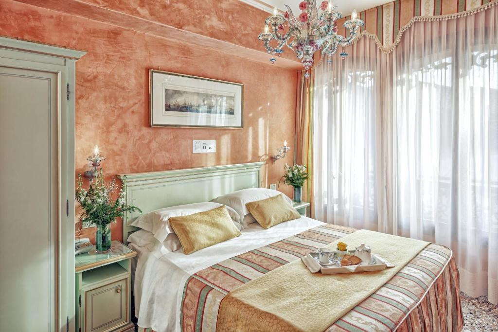 Un dormitorio con una cama con una bandeja de comida. en Hotel Firenze, en Venecia