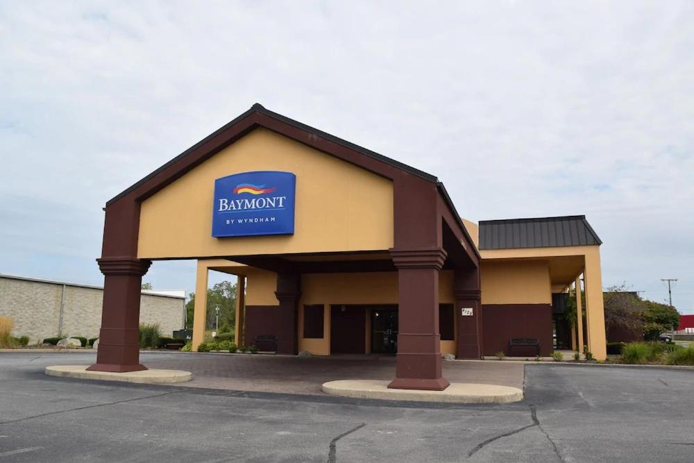 a building with a blue sign on top of it at Baymont by Wyndham Michigan City in Michigan City