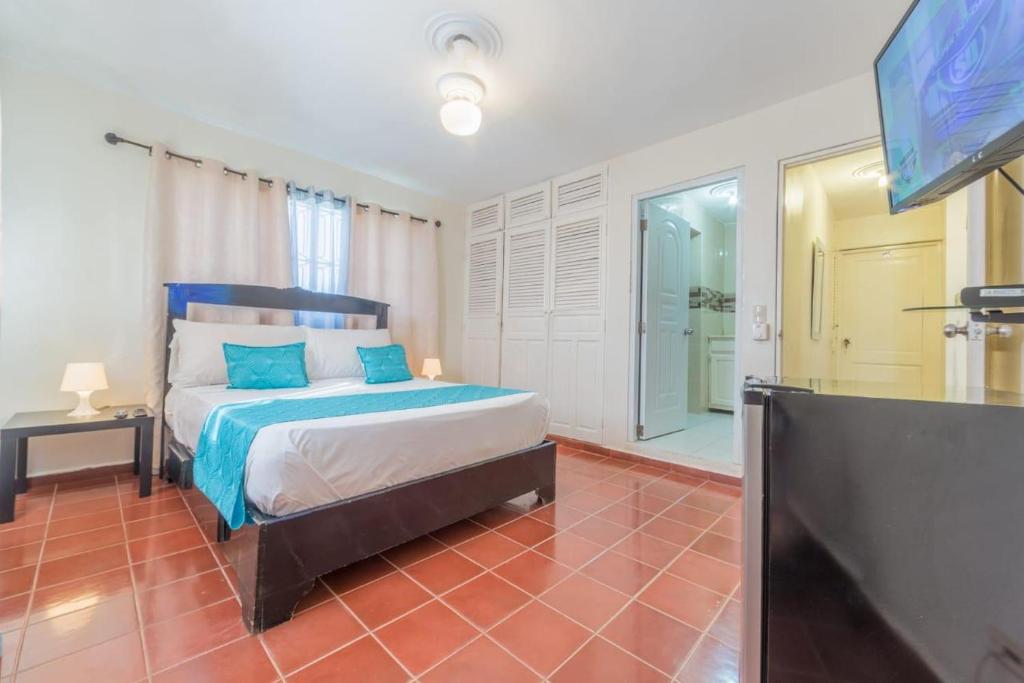 - une chambre avec un lit et une télévision à écran plat dans l'établissement Sosua Sweet Vacations, à Sosúa