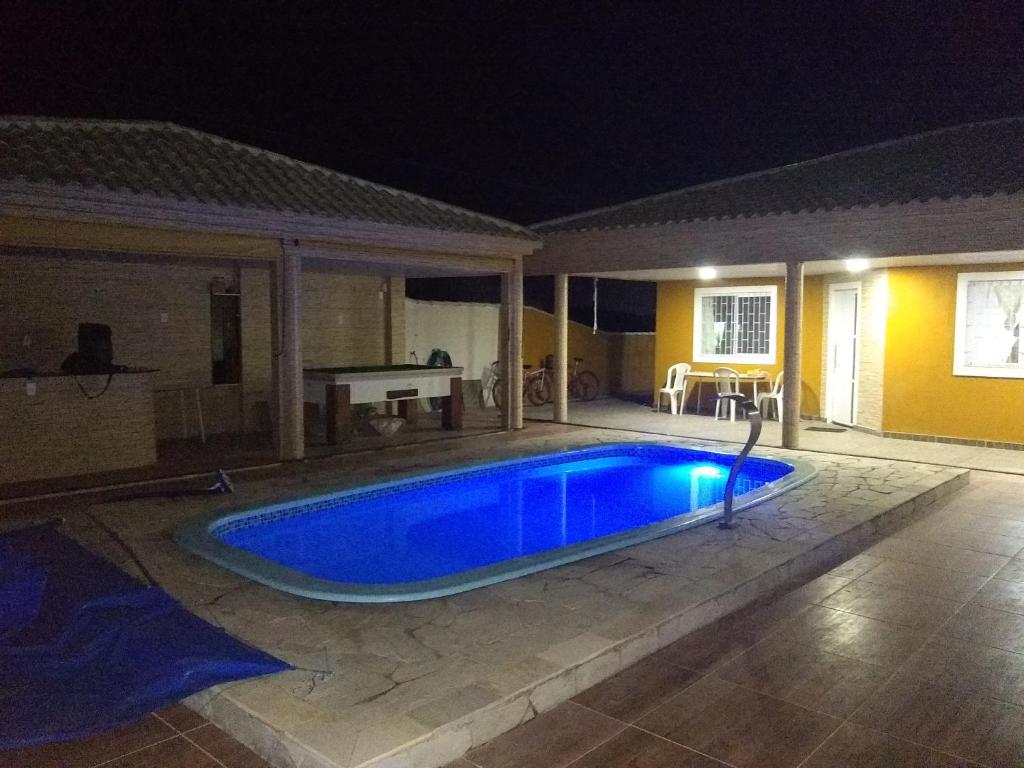 a swimming pool in the middle of a yard at night at Casa R7 in Maricá