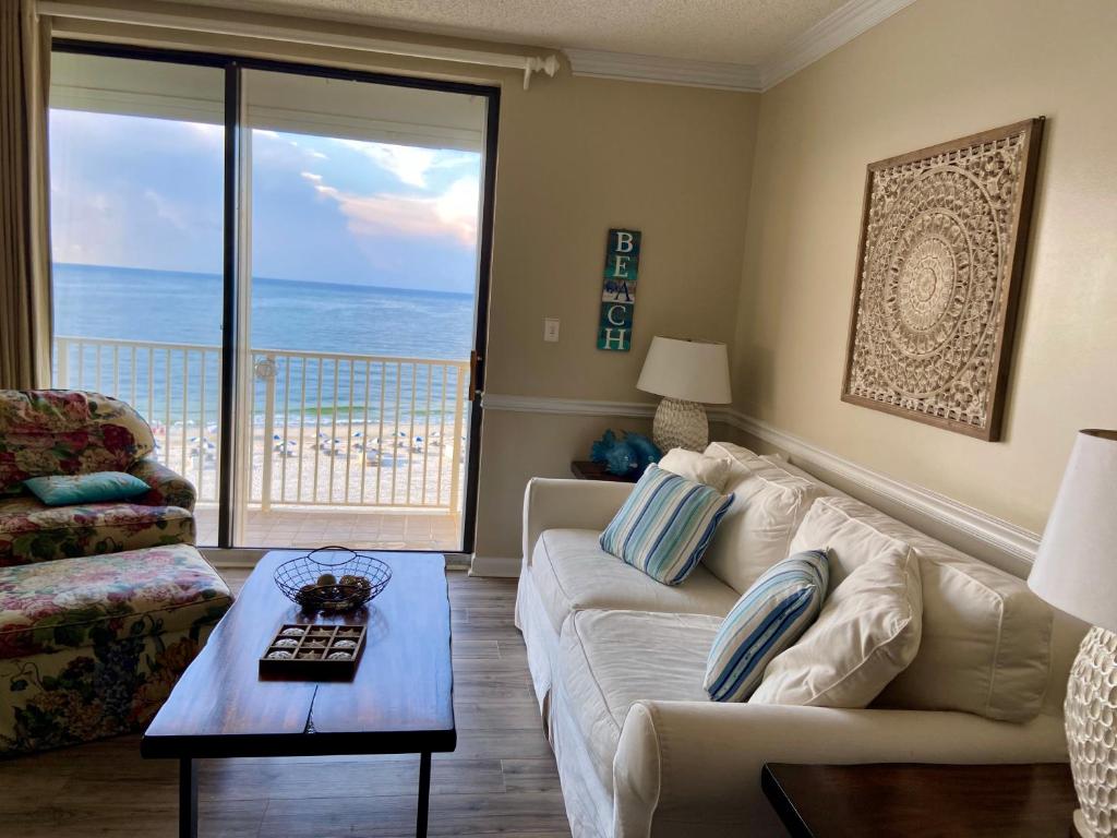 a living room with a couch and a view of the ocean at Shoalwater 704 in Orange Beach