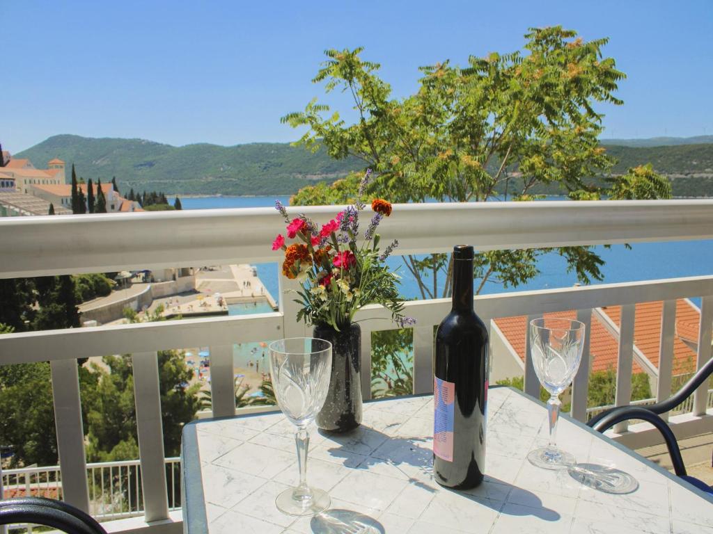 a bottle of wine sitting on a table with glasses at Apartments Jurković in Neum