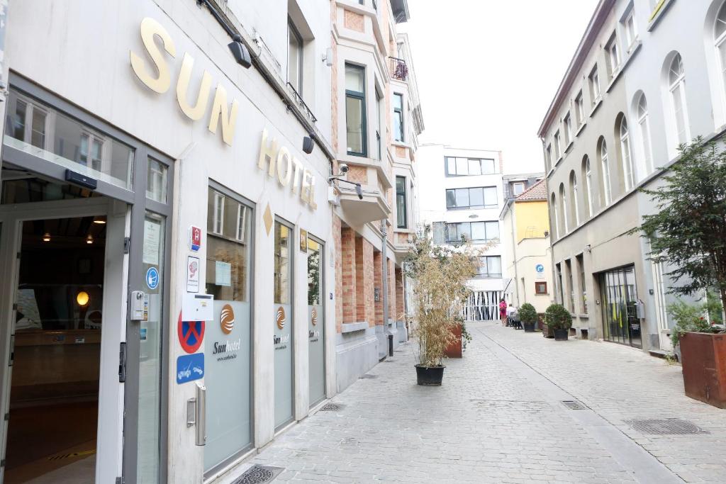 una calle con una tienda de sunoco al lado de un edificio en Sun Hotel, en Bruselas