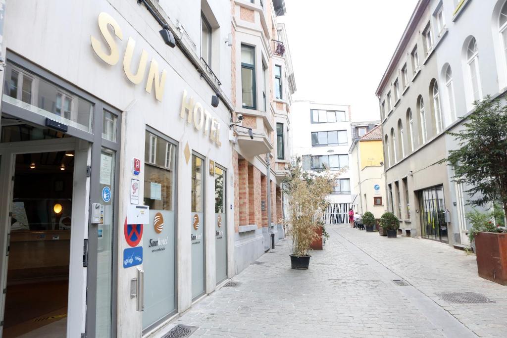 uma rua com uma loja Sunoco do lado de um edifício em Sun Hotel em Bruxelas