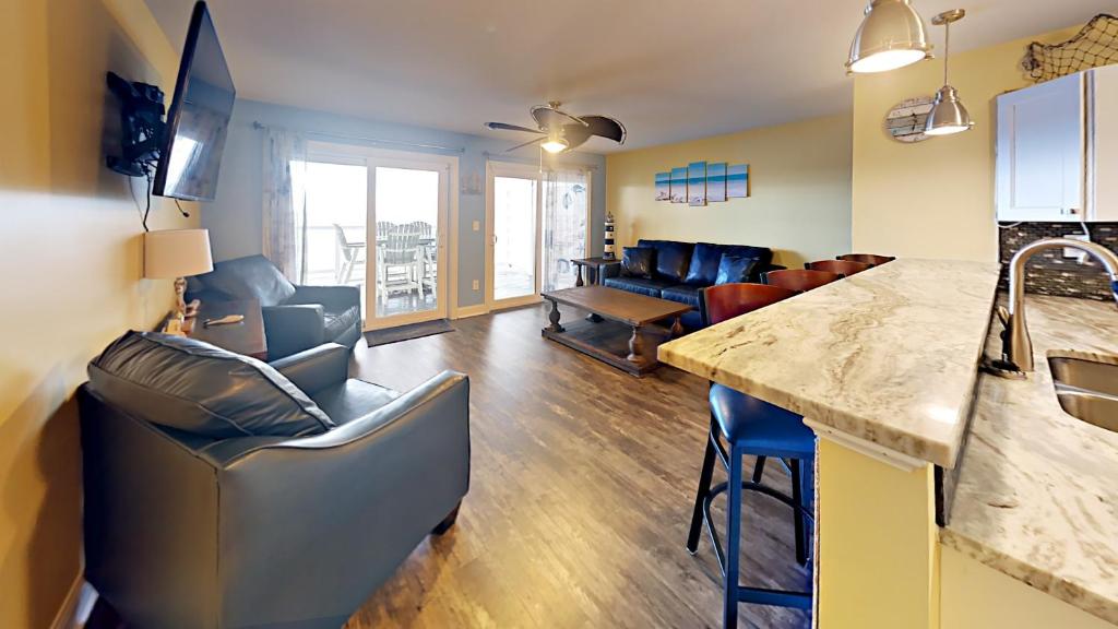 cocina y sala de estar con sillas y barra. en Put-in-Bay Waterfront Condo #104 en Put-in-Bay