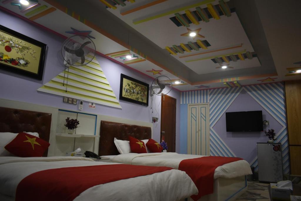 um quarto de hotel com duas camas e uma televisão em Hotel Star International em Rājshāhi