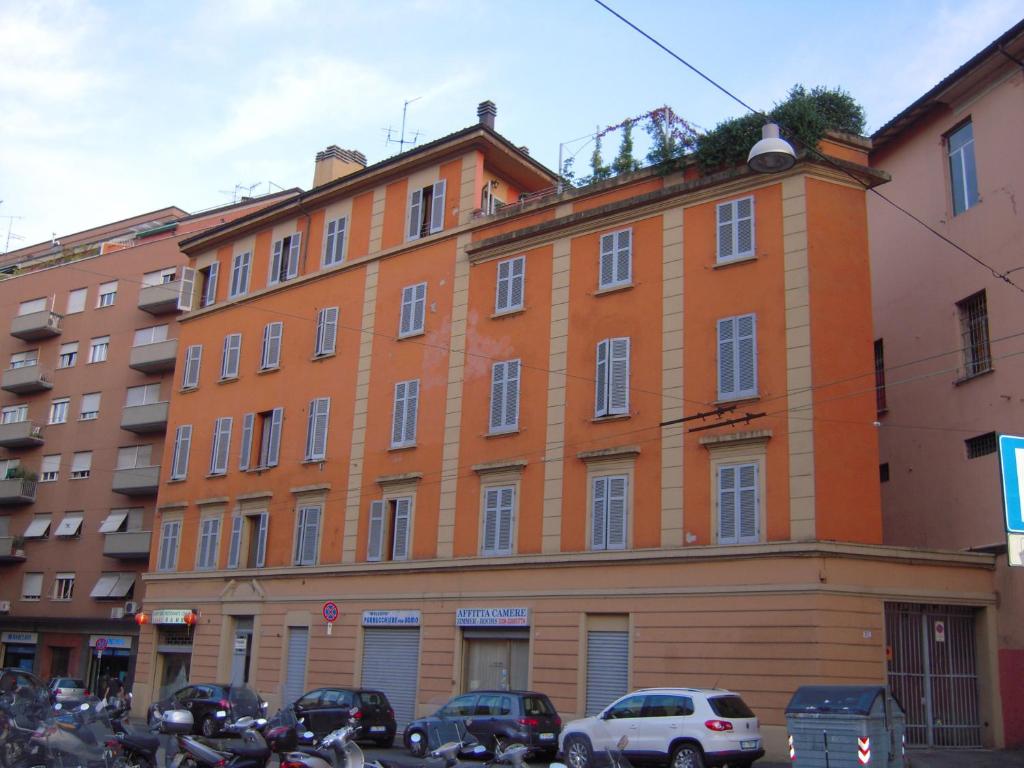ボローニャにあるリーヴァ リノ ゲストハウスの目の前に車を停めたオレンジ色の建物