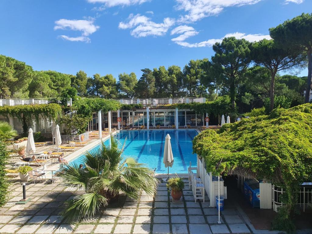 ein großer Pool mit Stühlen und Sonnenschirmen in der Unterkunft Hotel Gri-Mar in Llança