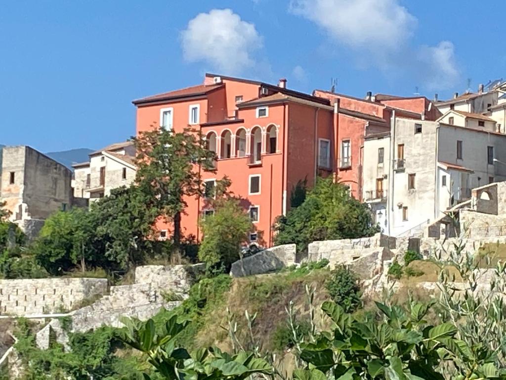 um grupo de edifícios numa colina com árvores em Palazzo Gentilizio de Maffutiis em Auletta