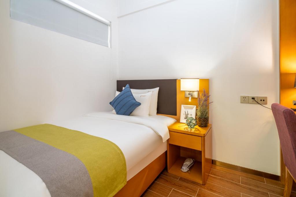 Postel nebo postele na pokoji v ubytování Dingshang Apartment Hotel