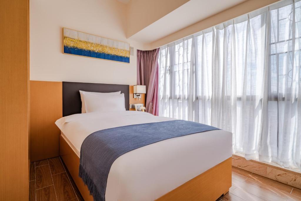 Postel nebo postele na pokoji v ubytování Dingshang Apartment Hotel