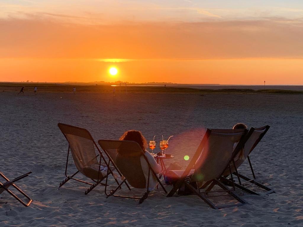twee mensen aan een tafel op het strand bij zonsondergang bij Les Capucines in Abbeville