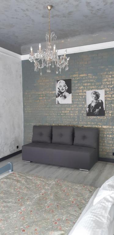 a living room with a couch against a brick wall at Apartment on Soborna 91 in Vinnytsya