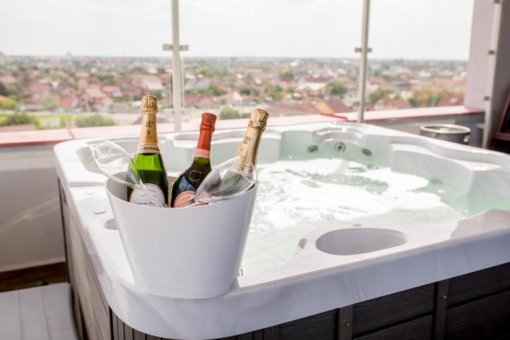 dos botellas de vino en un cubo en una bañera en Hotel Nevis Wellness & SPA, en Oradea