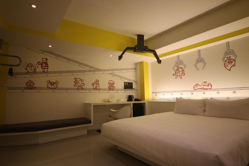 a bedroom with a white bed and a desk at Hotel Papa Whale-Kaohsiung Formosa Boulevard in Kaohsiung