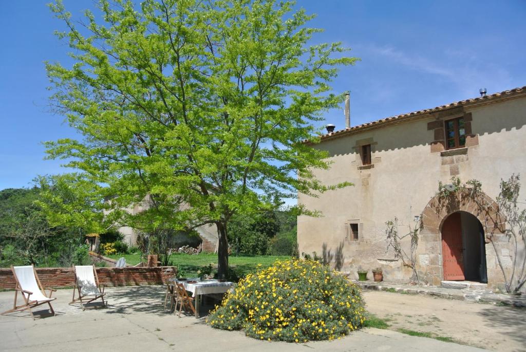 a house with a tree and a table and chairs at Masoveria del Mas Plaja de Fitor in Palafrugell