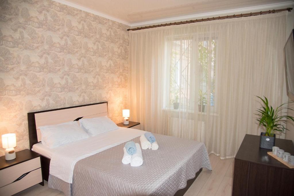 1 dormitorio con 1 cama con 2 zapatillas en Center of Odessa. Comfortable 2 rooms apartment en Odesa