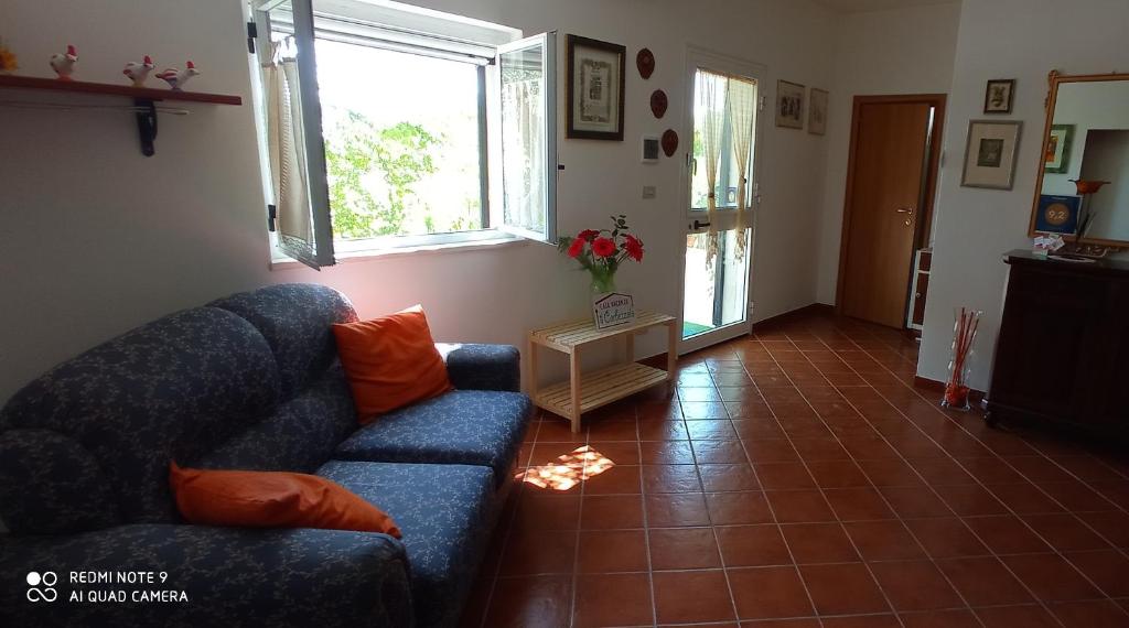 sala de estar con sofá azul y suelo de baldosa en Il Corbezzolo, en Matera