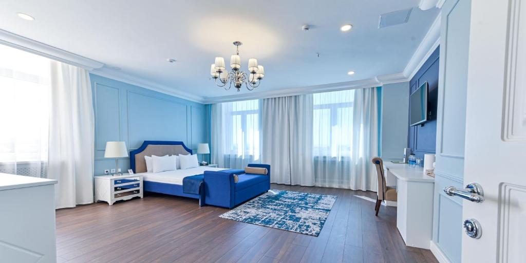 a blue bedroom with a blue bed and a blue couch at Reston Hotel & Spa in Ulan-Ude