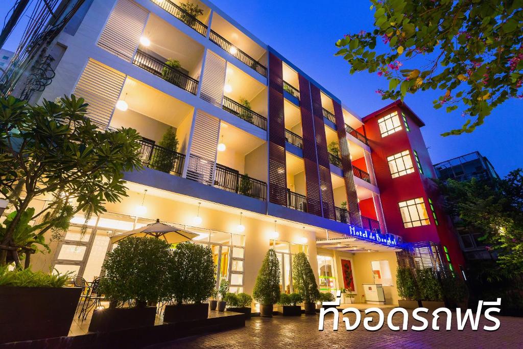 oświetlony budynek z drzewami przed nim w obiekcie Hotel De Bangkok w mieście Bangkok