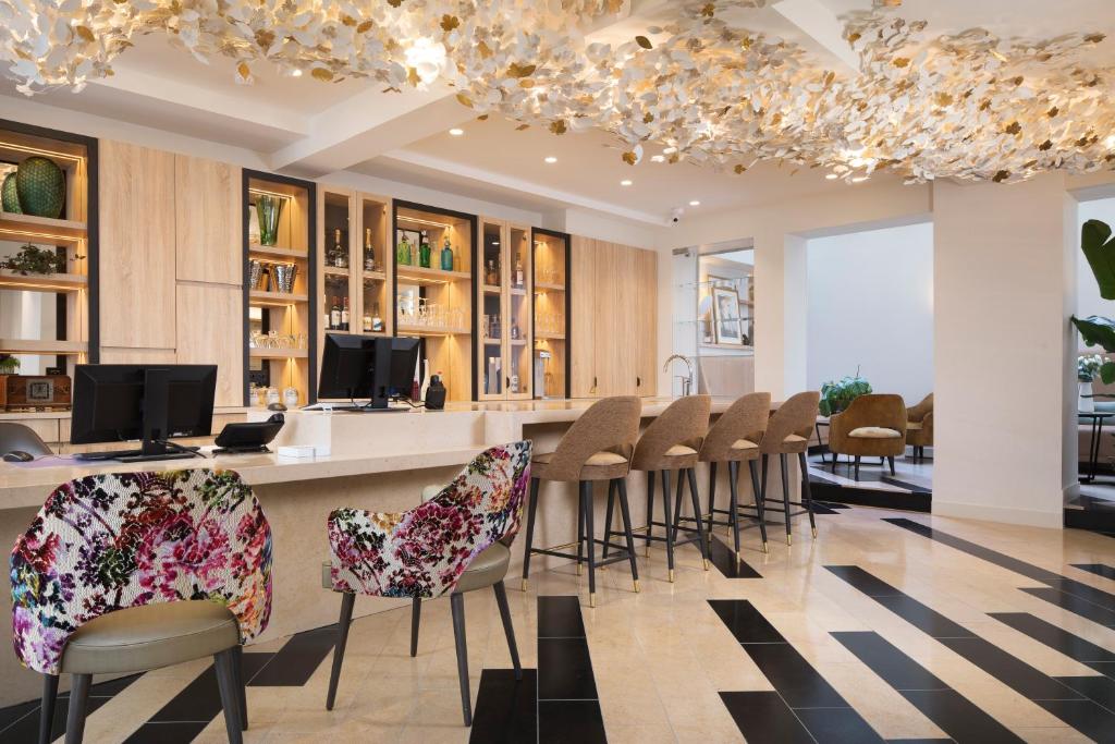 a lobby with a bar with stools and a bar counter at Hôtel des Champs-Elysées in Paris