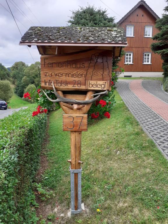 a sign in the grass in front of a house at Ferienhaus Grabs in Lichtenhain