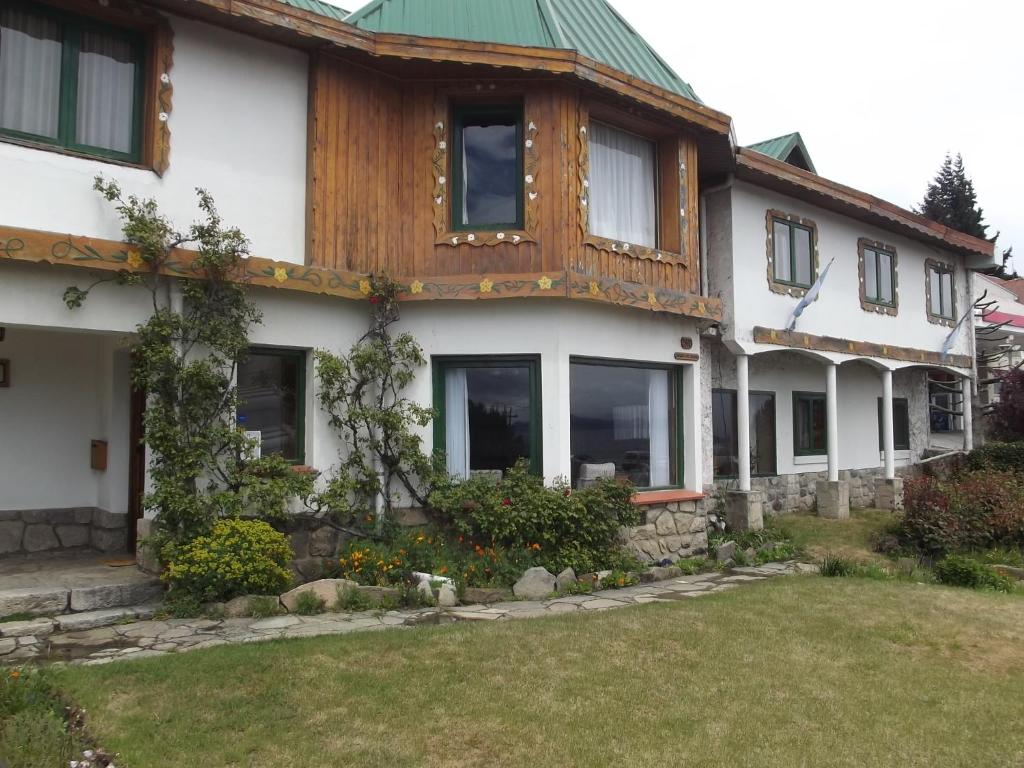 Casa blanca grande con techo verde en Hosteria Las Amapolas en San Carlos de Bariloche