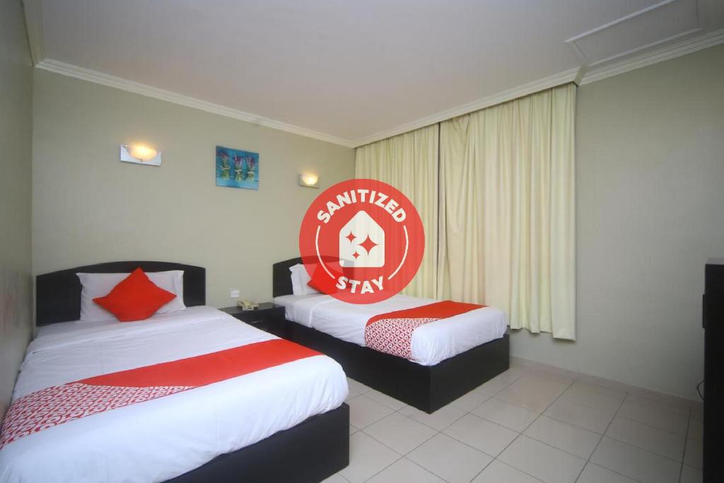 um quarto de hotel com duas camas e um sinal vermelho em Super OYO 1027 Hotel London em Sandakan