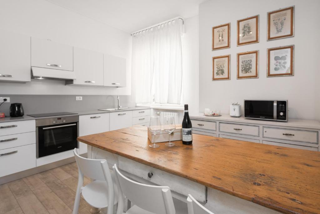 - une cuisine avec une table en bois et une bouteille de vin dans l'établissement Flats4Rent La dimora d'Orlando, à Vérone