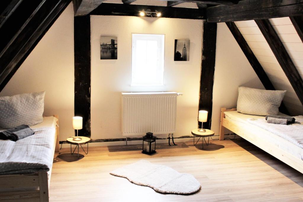 a attic bedroom with two beds and a window at Workers Apartment in Frickenhausen mit TV & WLAN in Frickenhausen